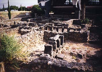 Looking south from the Synagogue at some of the excavated dwellings in Capernaum. Behind them, hovering like a flying saucer over St. Peter's house, is the St. Peter Memorial Chapel.