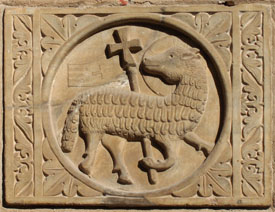 Medieval Agnus Dei with halo and cross; half-relief on the wall of the atrium, Euphrasian Basilica, Poreč, Croatia.